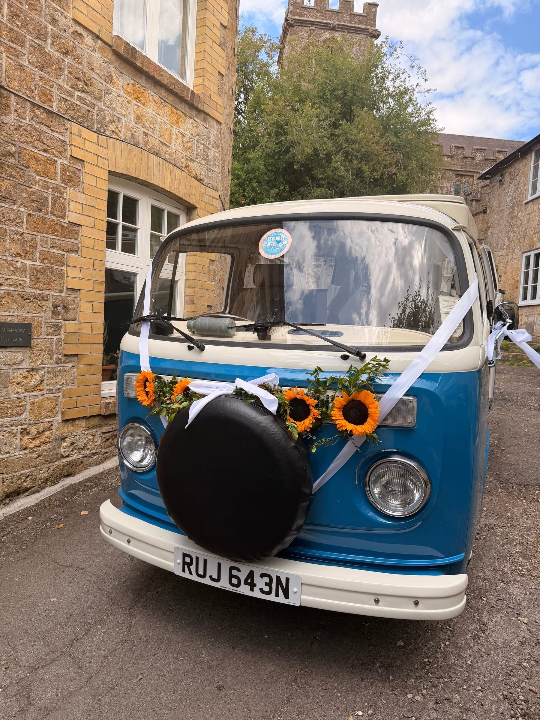 A campervan dressed with sunflowers, ready for the send-off